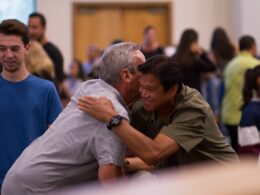 two men hugging on focus photography